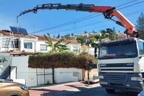 Camión grúa subiendo placas solares