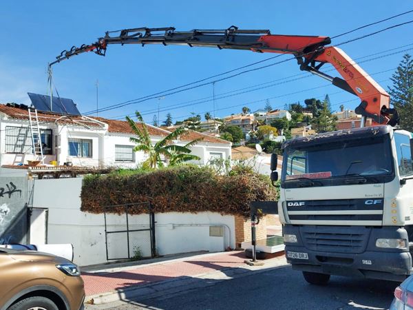 Camión grúa subiendo placas solares